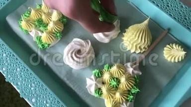 烹饪不同形状，颜色和大小的棉花糖.. 女人用糕点包添加了棉花糖的元素。 完成了